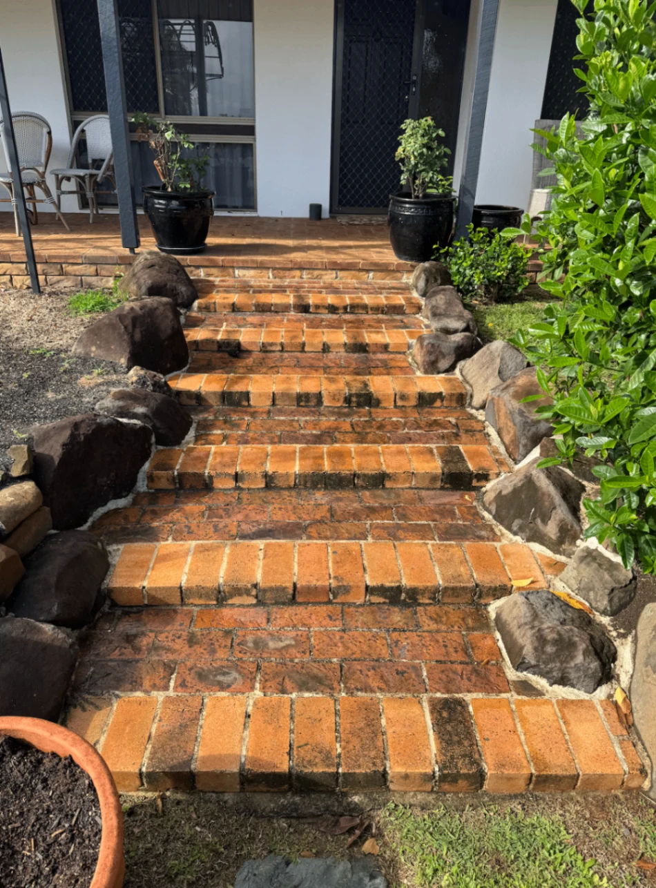 Brick entrance steps with dark stains and built-up grime