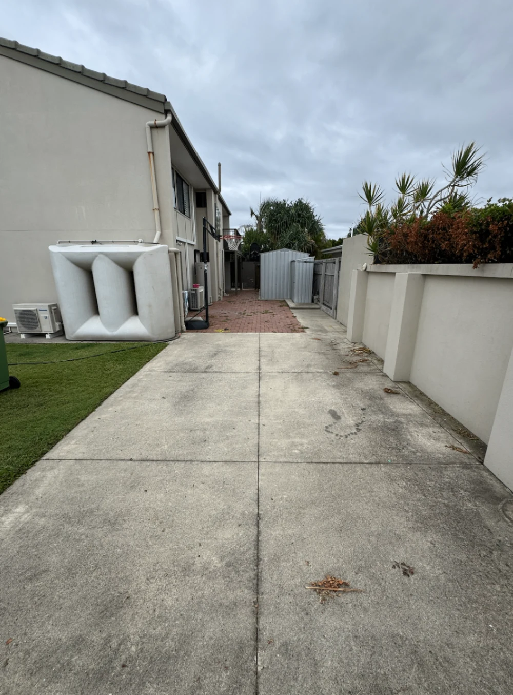Concrete driveway beside a home with accumulated surface grime