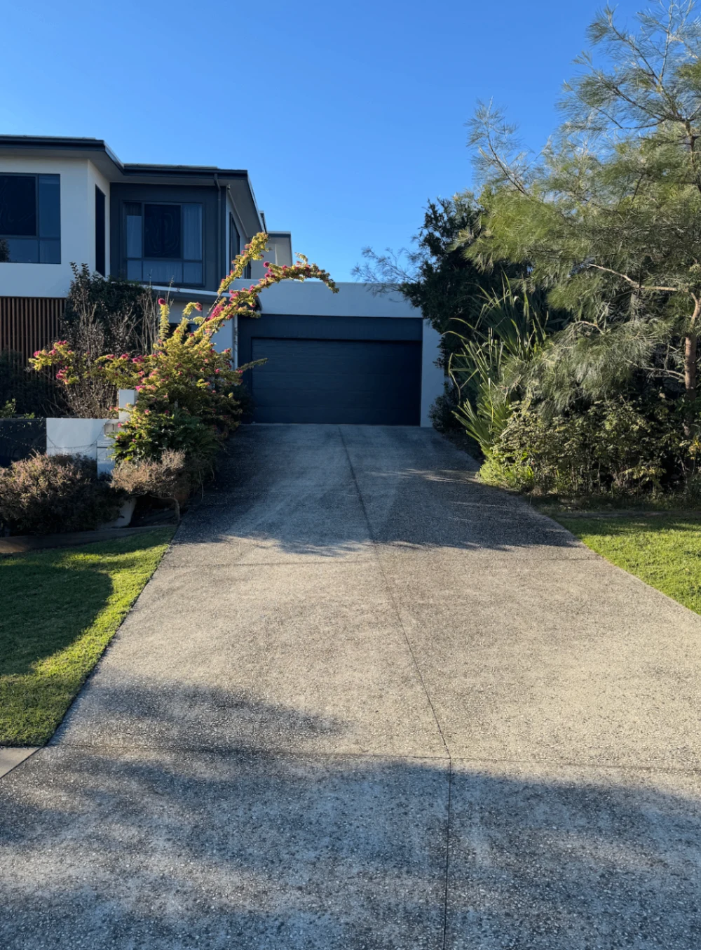 Sloping driveway with surface dirt leading to a residential garage