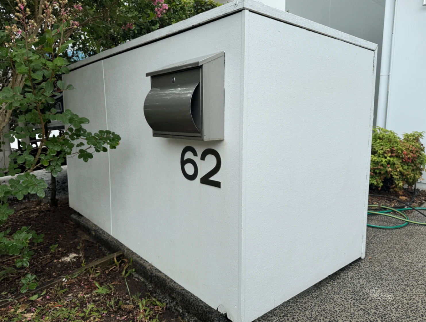 Freshly cleaned white rendered letterbox and surrounding garden