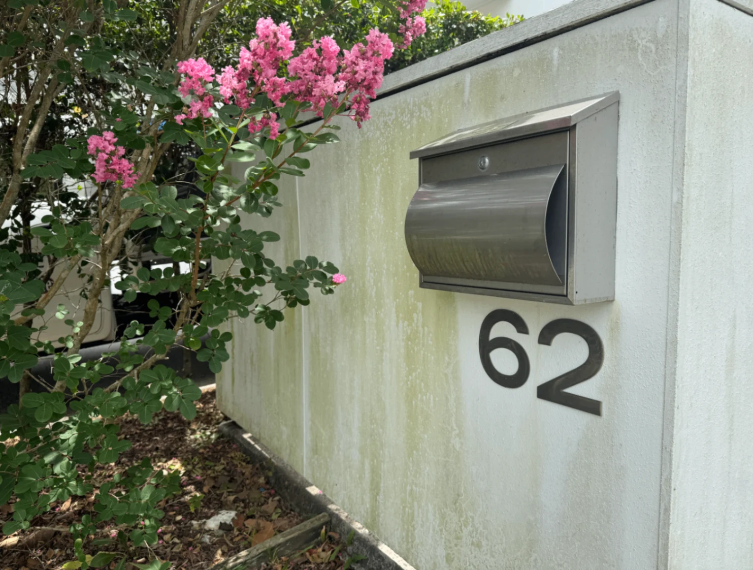 White rendered letterbox with accumulated mould and grime